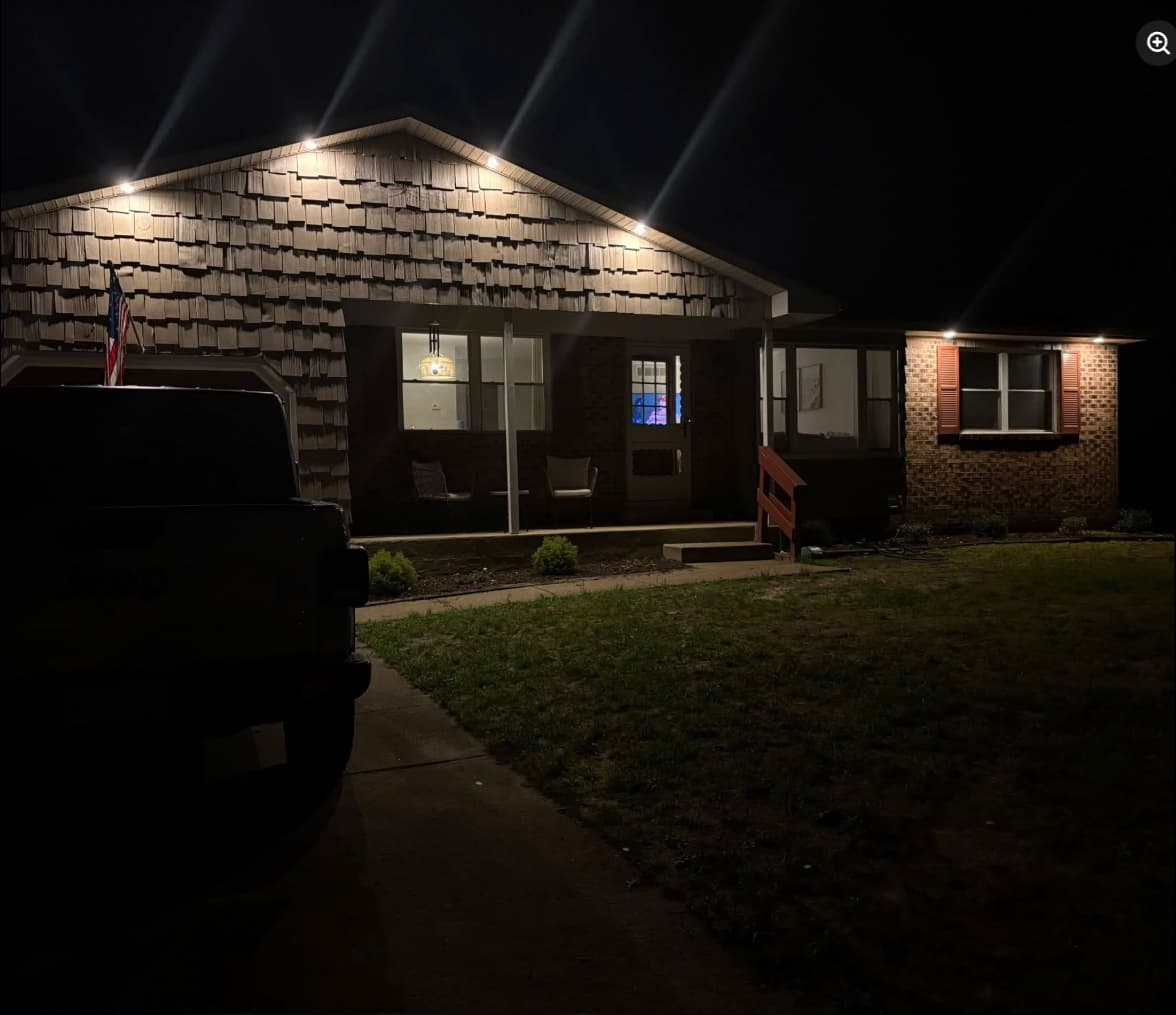 Exterior recessed lighting washing down the front of a shingled South Jersey ranch at night